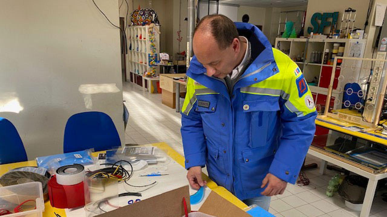 A coordinator of a local civil protection agency inspects the SciFabLab facial shields