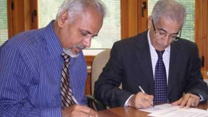 ICTP Director K. R. Sreenivasan (left) and Prof. A. M. Taleb, MOHESR representative, signing agreement that provides training for Iraqi scientists in Italian laboratories (ICTP Photo Archives/Roberto Barnaba)