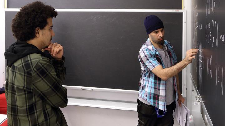 Two mathematicians working at a blackboard