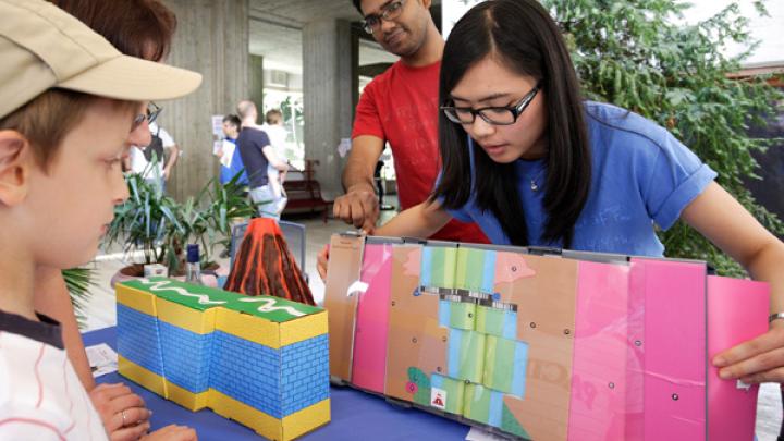 ICTP Postgraduate Diploma student Sarah Oliva explains how new crust is formed beneath the ocean to young visitors of ICTP's Mini Maker Faire in May 2015