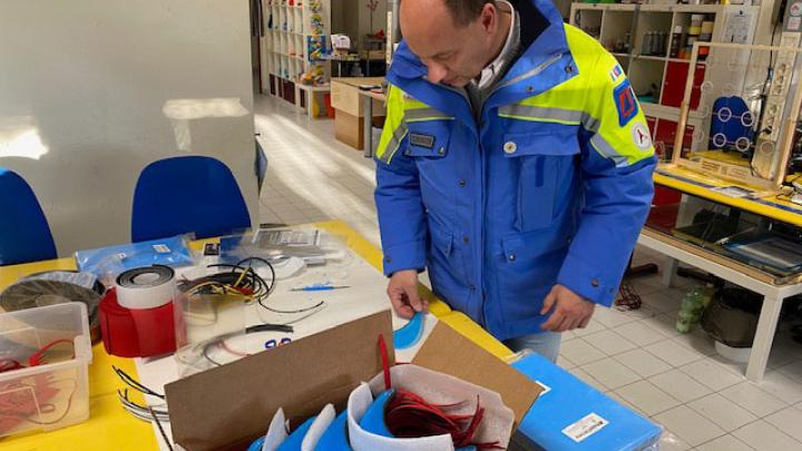 A coordinator of a local civil protection agency inspects the SciFabLab facial shields